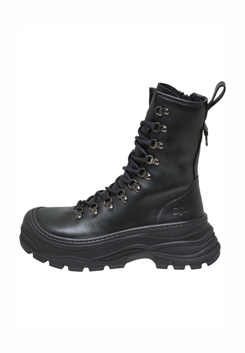 Botas de combate de cuero negro con caña alta, suela de goma texturizada, ojales de metal y cordones. Incluyen una lengüeta en la parte trasera para ponerlas y Quitarlas fácilmente.