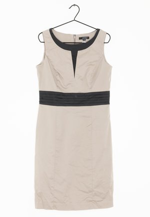 Abito beige con design senza maniche, tessuto nero a contrasto sul collo e in vita, texture morbida e lunghezza al ginocchio. Cerniera sulla schiena.