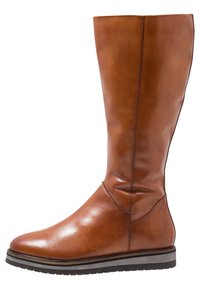 Botte en cuir brun montant avec une finition lisse, un bout légèrement arrondi et une semelle noire avec des rayures contrastantes. Détail de couture verticale visible.