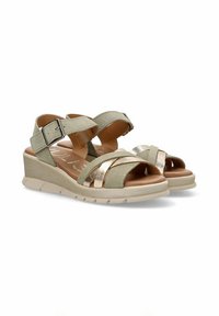 Sandalias de ante sintético beige con un acento metálico dorado, que cuentan con una correa de tobillo ajustable y una suela de cuña texturizada para mayor comodidad.
