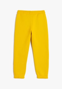 Gule sweatpants med elastisk talje, samlende manchetter og en glat tekstur. Enkel design, ingen synlige mønstre eller metaldele.