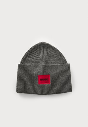 Gray ribbed knit beanie with a folded cuff, featuring a red rectangular label with "HUGO" printed in black.