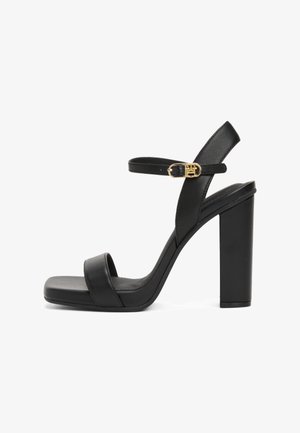 Mustad mustakõrgete kontsadega sandaalid, valmistatud siledast nahast, laia esirihmaga, pahkluu rihmaga, millel on kuldne pandla, ja suurte ruudukontsadega.