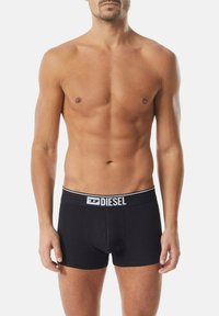 Svarta bomullsboxershorts med en vit midjeresår med logotyp, som har en åtsittande passform och slät textur. Minimalistisk design utan ytterligare mönster.