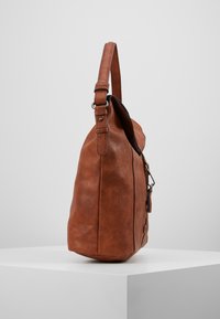 Borsa a spalla in pelle marrone con finitura testurizzata e una sola tracolla regolabile, dotata di chiusura con zip e dettagli laterali.