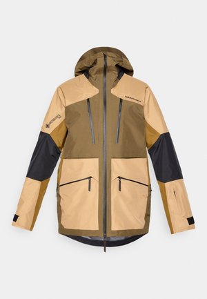 Hnedo-bežová GORE-TEX bunda s kapucňou, vybavená zipsovými vreckami a kontrastnými čiernymi akcentami na rukávoch a pleciach.