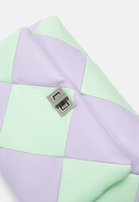 Prošívaná kabelka v mátově zelené a levandulové kůži, vybavená stříbrným obdélníkovým zapínáním a bezproblémovým, strukturovaným designem.