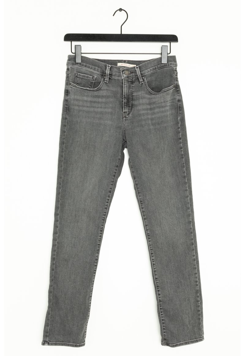 Jean slim gris avec poches avant et passants de ceinture suspendu sur un cintre noir contre un fond blanc.