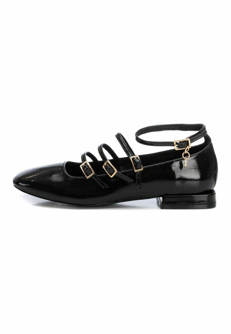 Zapatos planos de charol negro con punta afilada, tres correas con herrajes dorados y un tacón cuadrado bajo.