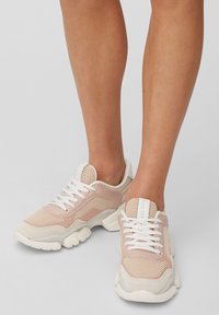 Baskets de sport rose clair en mesh et daim, avec des accents blancs, une semelle épaisse et un bout rond. Comprennent des lacets blancs et un logo.