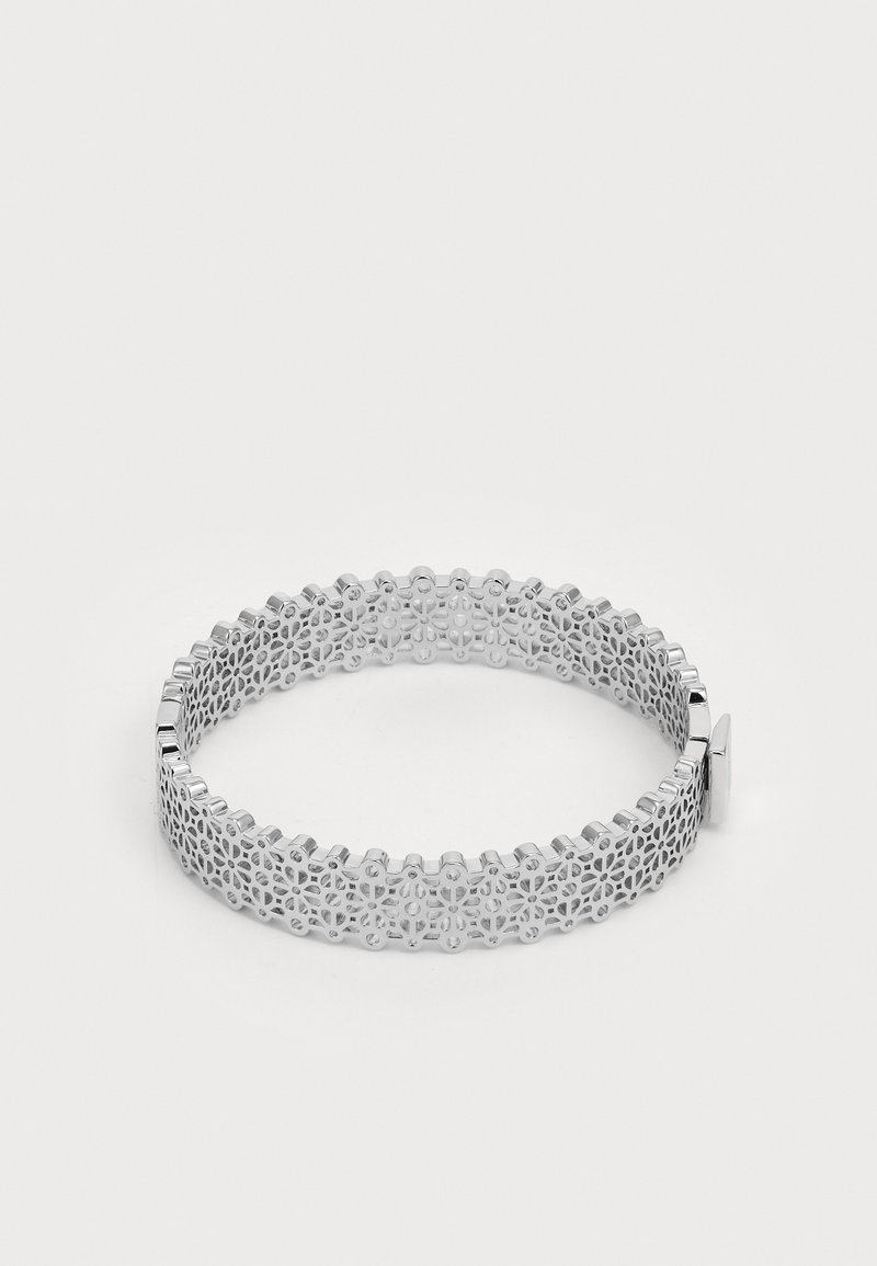 Sølvmetallarmbånd med et intrikat utskåret blomstermønster, med en jevn finish og lås. Rund form, lett konstruksjon.