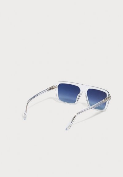 Lunettes de soleil avec une monture en plastique transparent et des verres rectangulaires à dégradé bleu posées sur une surface blanche.