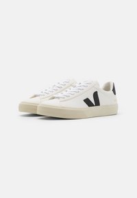 Weiße Leder-Sneaker mit schwarzen Akzenten, runder Zehenpartie, weißen Schnürsenkeln und strukturiertem Gummisohle. Hervorstechendes "V"-Logo an der Seite.