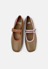 Chaussures Mary Jane marron avec des sangles corail et lavande contrastantes. Texture en cuir lisse avec un design à bout carré et semelles intérieures marquées.