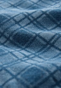 Blauw textiel met een getextureerd ruitpatroon in verschillende tinten blauw, met een zachte, geweven stofstructuur.