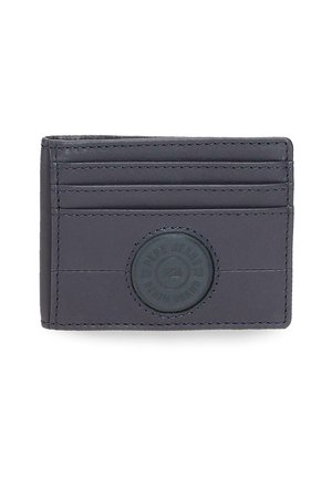 Tarjetero delgado de cuero gris oscuro con cuatro ranuras horizontales para tarjetas y un parche redondo con logo en relieve en el centro frontal.