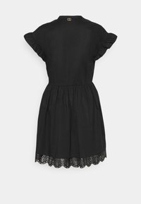 Svart klänning med korta volangärmar, insvängd midja och scallopkant med intrikata utskärningar. Bakom nacken finns guldhardware.