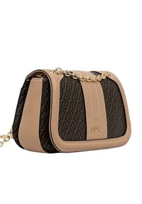 Bolso de mano marrón con patrón, base de cuero liso beige, cadena dorada como asa y logotipo en relieve en el frente. Forma estructurada con detalles de costura.