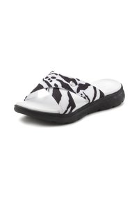 Black and white striped slide sandal with crisscross straps, rubber sole, and textured footbed. Features a metal accent on the strap.
