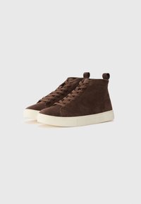 Brown suede high-top sneakers with a white rubber sole, featuring flat laces and heel pull tab. Smooth texture with minimalist design.