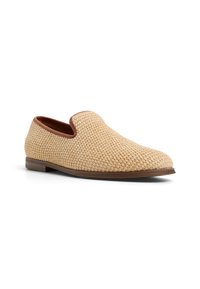 Woven slip-on shoe in light beige with brown trim, featuring a rounded toe and textured upper. Flat brown sole with subtle detailing.