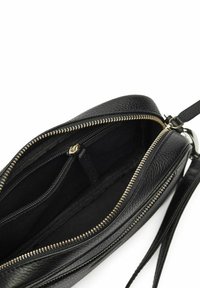 Svart läderclutch med en guldfärgad dragkedja och flera inre fack. Har en jämn textur och ett avtagbart handledsband.