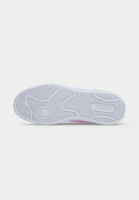 Λευκή λαστιχένια σόλα παπουτσιού Puma με υφή για καλύτερο κράτημα και το λογότυπο Puma κοντά στη φτέρνα, σε απλό λευκό φόντο.