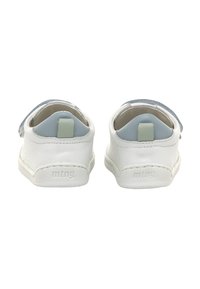 Zapatos de cuero blanco sin cordones con acentos azules, que cuentan con una superficie texturizada y una pequeña lengüeta en el talón. Nombre de la marca "mtng." embossado en el costado.
