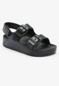 Sort sandal med to justerbare stropper med spænder, formet fodseng og en tekstureret gummisål for bedre greb.