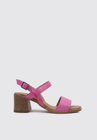 Sandale en cuir rose avec sangle cheville réglable, design à bout ouvert et talon en bois épais. Semelle plate avec des détails cousus.