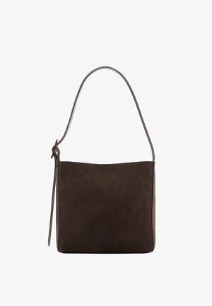 Bolso de hombro de ante marrón oscuro con una sola correa y un lazo decorativo delgado en el lado izquierdo sobre un fondo blanco.