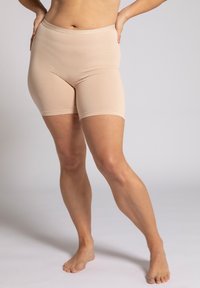 Pantaloni corti beige senza cuciture con vita alta, realizzati in tessuto elasticizzato. Hanno una superficie liscia e un bordo elastico lungo la vita.