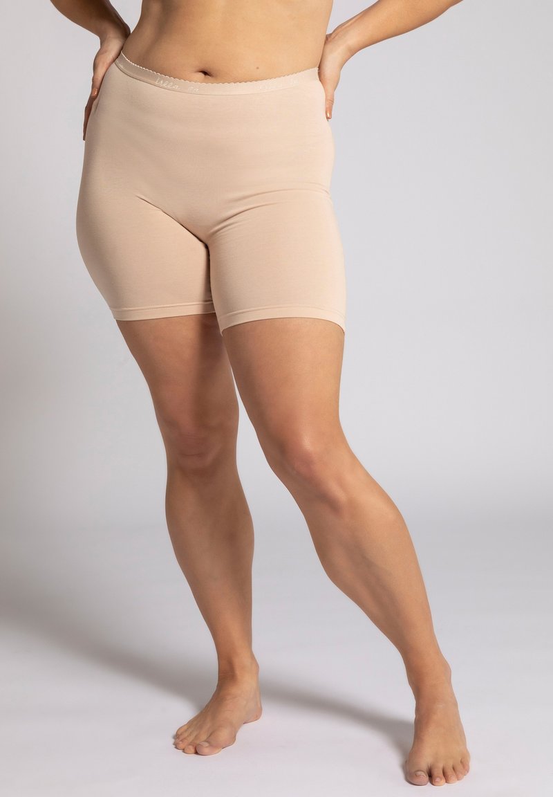 Pantaloni corti beige senza cuciture con vita alta, realizzati in tessuto elasticizzato. Hanno una superficie liscia e un bordo elastico lungo la vita.