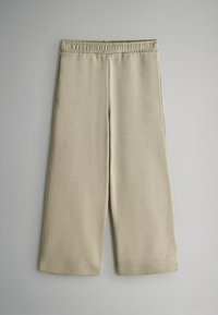 Bežové nohavice so širokými nohavicami vyrobené z mäkkej látky, s elastickým pásom a prešitými okrajmi, s hladkou textúrou a minimalistickým dizajnom.