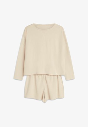 Beżowy zestaw odzieży do relaksu z bawełny, składający się z długiego rękawa topu w kroju crop z okrągłym dekoltem oraz szortów z elastycznym pasem. Gładka tekstura, minimalistyczny design.