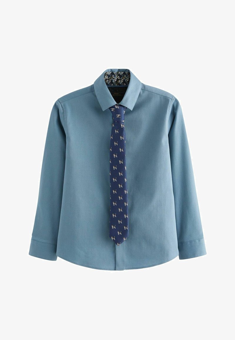 Cămașă albastru deschis, cu mânecă lungă, cu guler butonat și o cravată bleumarin decorată cu mici modele de câini. Textură de material moale și neted.