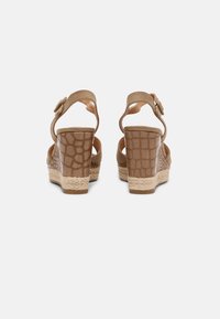 Braune Plattform-Sandalen mit einem strukturierten Krokodil-Muster, verstellbarem Riemen und sohlen im espadrille-artigen Stil.