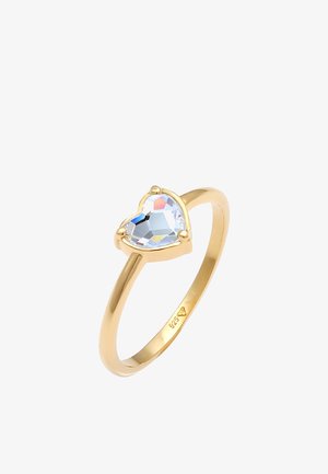 Bague plaquée or mettant en valeur un cristal taillé en forme de cœur dans un sertissage en griffes. Intérieur de la bande marqué "925" indiquant la teneur en argent.