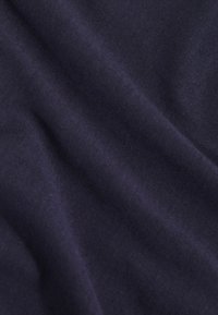 Tissu bleu marine avec une texture douce et une surface lisse, présentant de légers plis et froissements. Couleur uniforme sans motifs visibles.