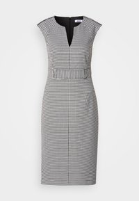 Robe sans manches noire et blanche à motif pied-de-poule, longueur genou, avec encolure crantée et ceinture assortie à la taille.