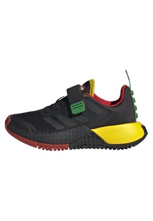 Black athletic shoes with a mesh upper, yellow midsole, red and green accents, and a Velcro strap. Textured outsole for grip.