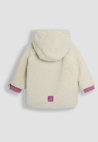 Vit fleecejacka med huva, med rosa ribbade ärmar och en lila etikett på baksidan. Mjuk textur och lös passform.