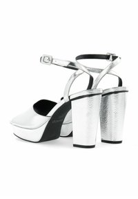 Zilveren plateau-sandalen met een gestructureerde metallic afwerking, open teen, enkelbandje en chunky hak. Zwarte voering en zool zichtbaar.