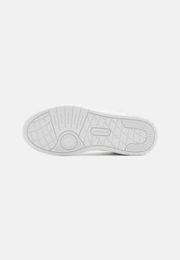 Hvitt gummisåle til sneaker med teksturerte grep mønstre, sirkulært akzent, og merkevarelogo preget. Glatte avrunde kanter, minimalistisk design.