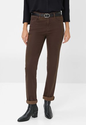 Braune Baumwollhosen mit schmalem Schnitt, umgeschlagenen Säumen und Fronttaschen. Getragen mit einem schwarzen Gürtel und Stiefeletten.