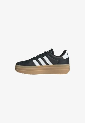 Black athletic shoe with white three-stripe design, textured synthetic upper, thick beige sole, and a padded collar for comfort.