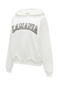 Biela mikina s kapucňou, na ktorej je vyšívaný nápis "LAMANIA" v čiernej farbe. Má dlhé rukávy, predné vrecko a voľný strih.