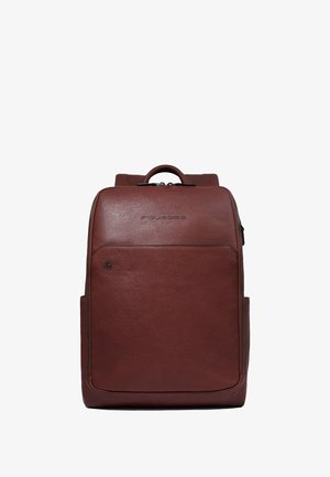 Mochila de cuero marrón con textura suave, forma rectangular, bolsillo delantero con cremallera y asa superior. Presenta un logotipo en la parte frontal.