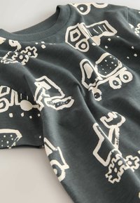 Dark gray cotton long-sleeve shirt featuring white graphic patterns of vehicles and tools. Round neckline with ribbed trim.