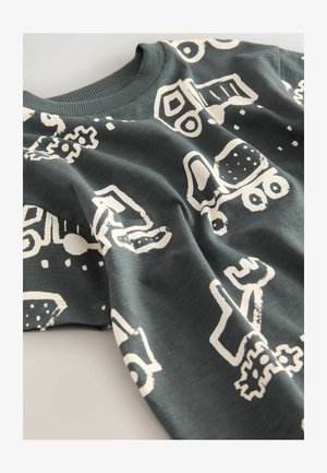 Tumši pelēki kokvilnas krekls ar garām piedurknēm, kurā ir baltas grafiskas zīmējumi ar transportlīdzekļiem un rīkiem. Apaļa apkakle ar ribotiem trimmiem.